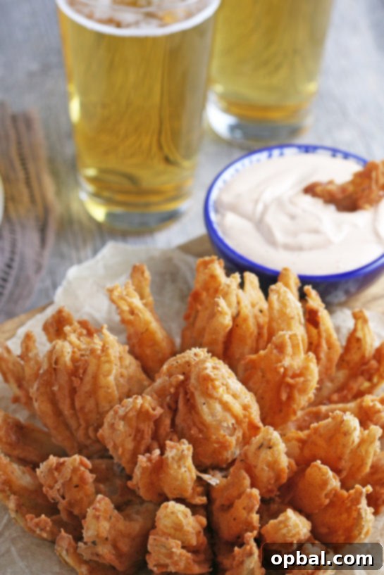 Golden Blossom Onion 15 Deep-Fried Blooming Onion, beautifully golden and crispy, served with a rich homemade dipping sauce. This ultimate appetizer recipe transforms a sweet onion into an incredible, delicious snack perfect for game day or any occasion!