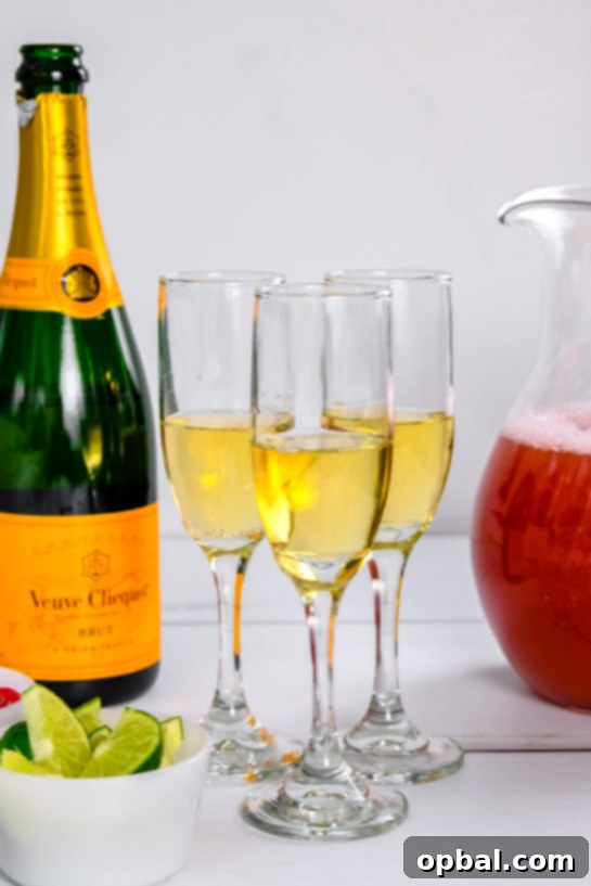 Festive Mimosas 5 Champagne being carefully poured into a glass, forming the bubbly foundation for a delicious Holiday Mimosa cocktail.