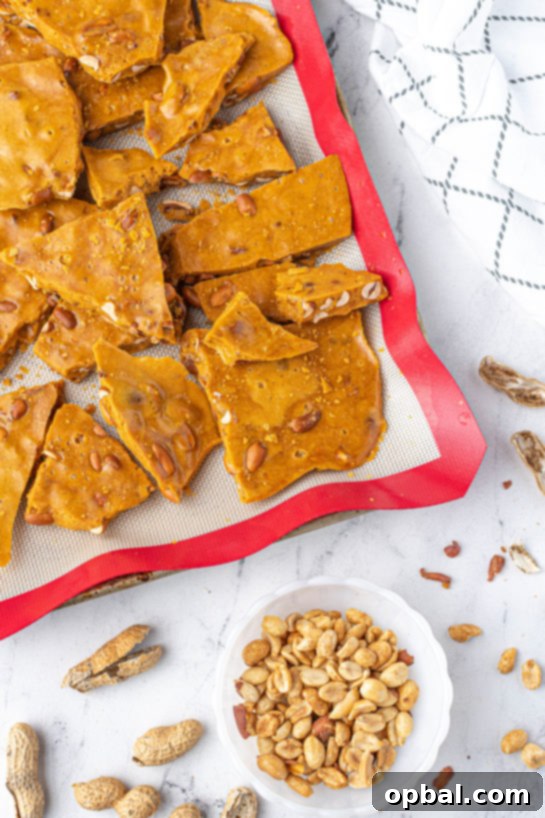 Quick Microwave Peanut Brittle 12 Breaking apart the brittle on the baking pan to make the Microwave Peanut Brittle recipe