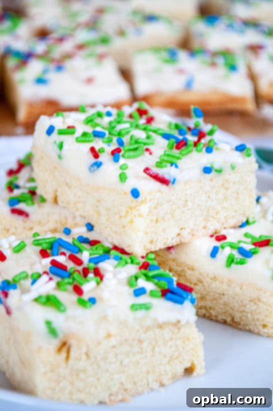 Sparkling Holiday Sugar Cookie Bars 2 Delicious Holiday Sugar Cookie Bars with festive sprinkles on a serving plate