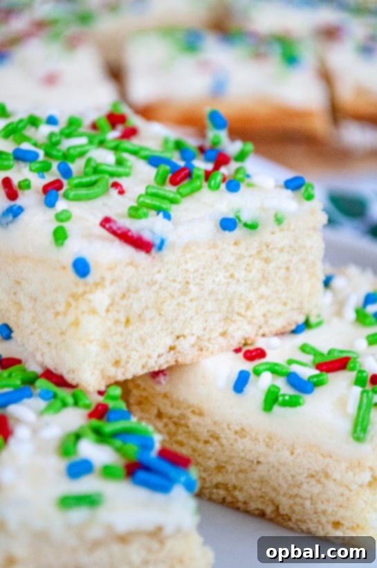 Sparkling Holiday Sugar Cookie Bars 10 Close-up image of a single Holiday Sugar Cookie Bar with sprinkles on a plate