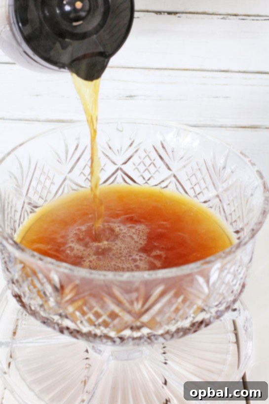 Effortless Iced Coffee Punch 5 Freshly brewed coffee being carefully poured into a large punch bowl, forming the delicious base for the coffee punch recipe.