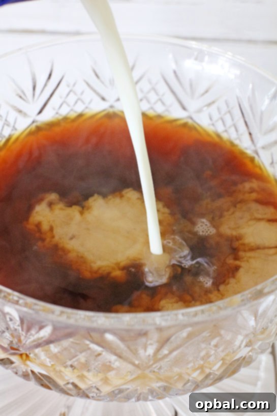 Effortless Iced Coffee Punch 6 Rich vanilla coffee creamer being poured into the chilled brewed coffee, contributing to the punch's smooth and creamy texture.