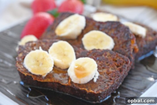 Ultimate Banana Bread French Toast 3 Close-up of Banana Bread French Toast with a drizzle of syrup and powdered sugar.