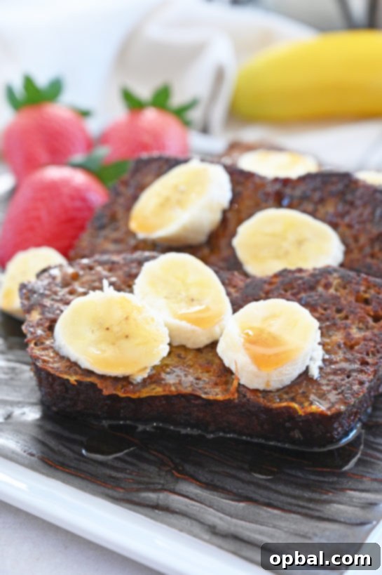 Ultimate Banana Bread French Toast 4 Three slices of fluffy Banana Bread French Toast topped with a rich caramel sauce and banana slices.