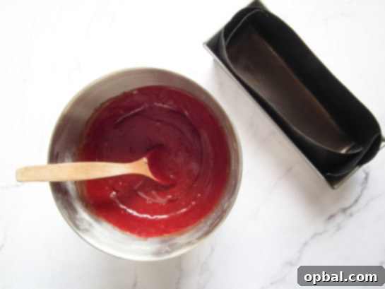 Mixing red food coloring into the red velvet batter for truffles.