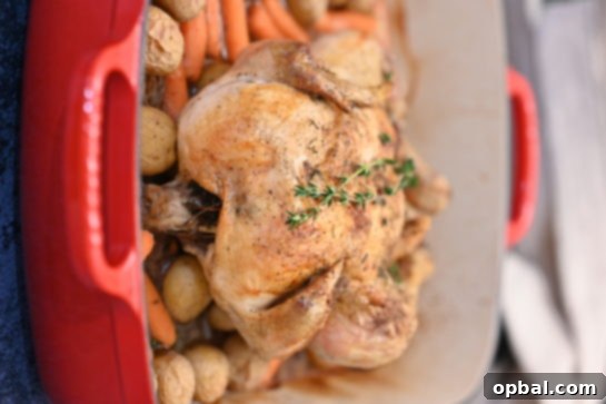 Golden Roasted Chicken with Garden Fresh Vegetables 4 A whole raw chicken on a cutting board, generously seasoned with salt and pepper, ready for roasting, with fresh rosemary sprigs nearby.