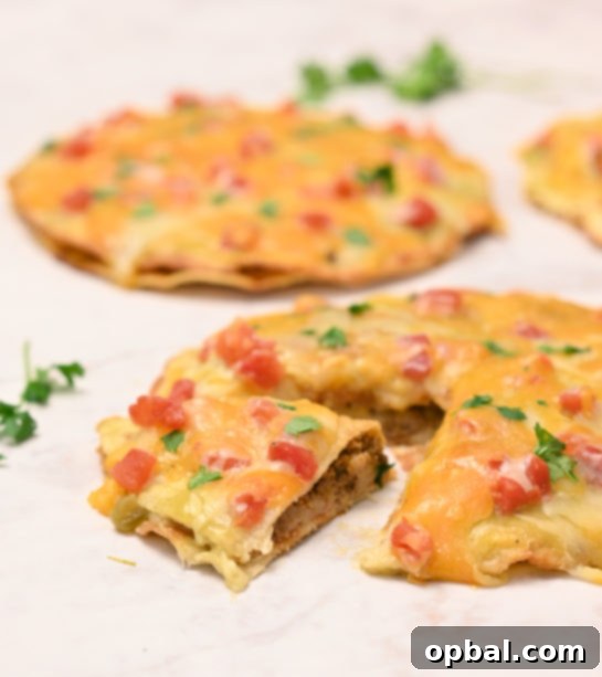 DIY Taco Bell Mexican Pizza Perfection 4 A slice of homemade Mexican Pizza being lifted, revealing the layers of crispy tortilla, seasoned ground beef, and refried beans underneath the melted cheese.