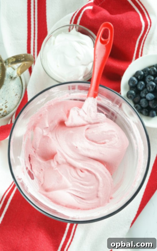 Stars and Stripes Fluff Bliss 4 Mixing Jell-O powder and whipped cream together as the first step for the easy Red White and Blue Fluff Salad.