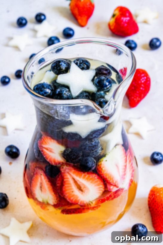 Freedom Sangria 11 A pitcher of patriotic sangria, brimming with colorful fruits, ready to be poured and served for a festive summer occasion.