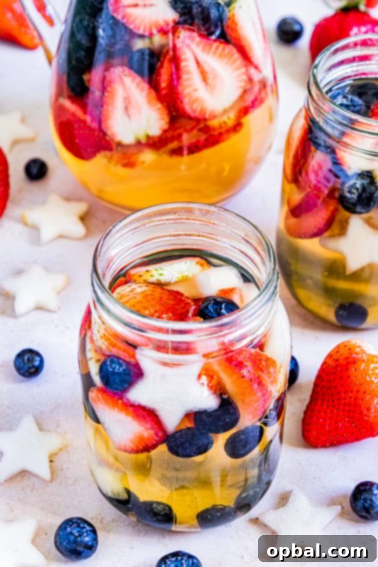 Freedom Sangria 12 A glass of Patriotic Sangria with red, white, and blue fruit, set against a summer backdrop, perfect for holidays.