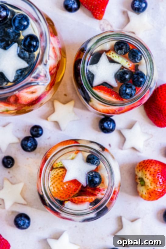 Freedom Sangria 10 An overhead shot of patriotic sangria in a large glass bowl, surrounded by individual glasses, ready for a Fourth of July party.
