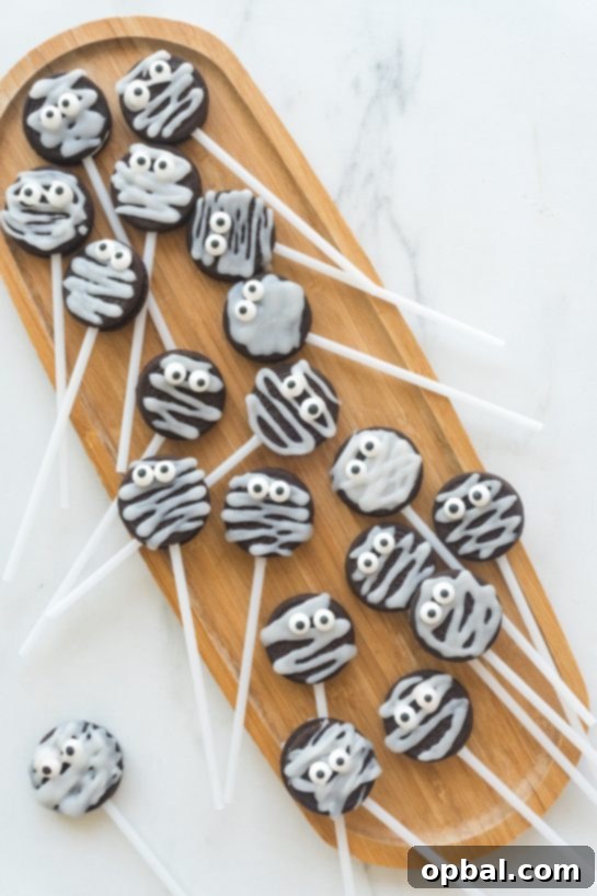 Halloween Mummy Oreo Pops 3 Close-up of three Mummy Oreo Pops showing their spooky candy eyes and white icing wraps