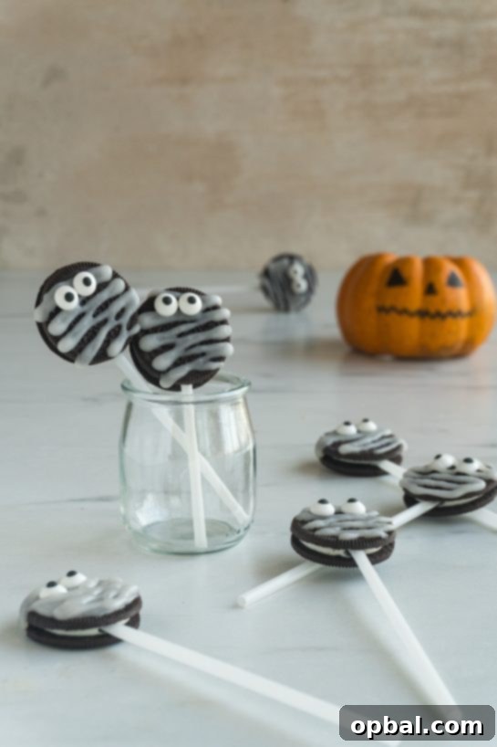 Halloween Mummy Oreo Pops 4 Overhead shot of all ingredients laid out for Mummy Oreo Pops: Oreos, powdered sugar, water, candy eyes, and lollipop sticks