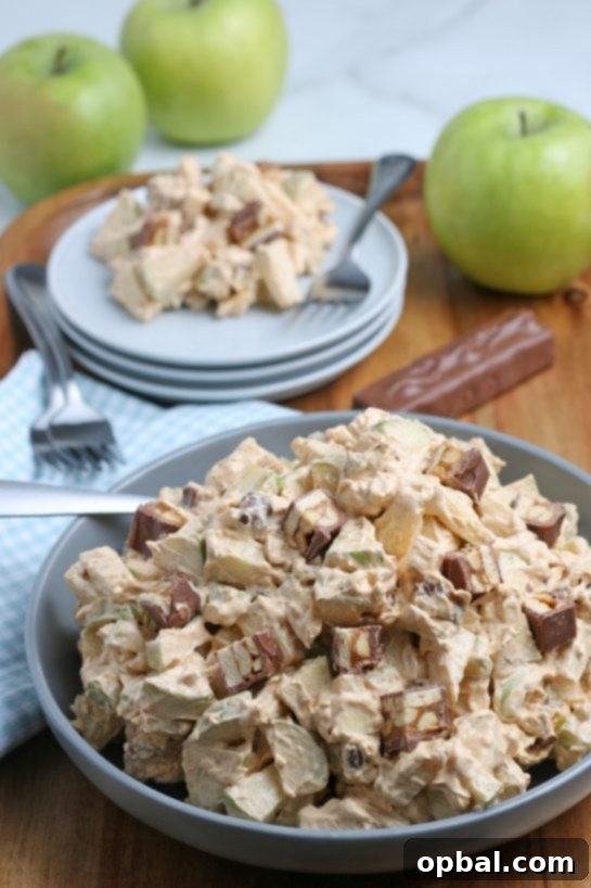 Caramel Apple Snickers Delight 2 A vibrant bowl of Caramel Apple Snickers Salad, showcasing crunchy green apples, creamy whipped topping, and delicious Snickers candy pieces. Ideal for festive occasions and casual potlucks.