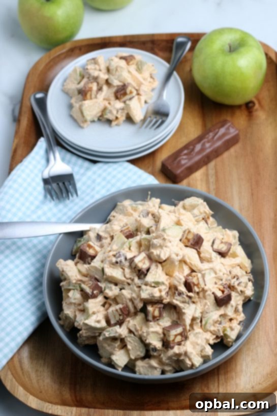 Caramel Apple Snickers Delight 12 The Caramel Apple Snickers Salad, presented in a large serving bowl, ready to be scooped and enjoyed. A fantastic recipe for fall holidays and potlucks, featuring apples, whipped topping, and Snickers.