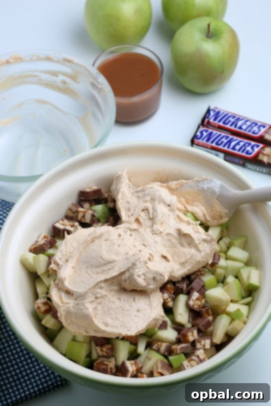 Caramel Apple Snickers Delight 6 Creamy whipped topping is gently folded into the apple and Snickers mixture, creating a light and luscious Caramel Apple Snickers Salad.