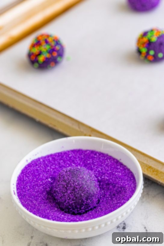 Enchanting Witch Hat Delights 9 Dough balls being rolled in the sanding sugar for the Halloween Witch Hat Cookies Recipe