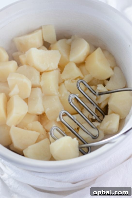 Amish Country Mashed Potatoes 6 Mashing the potatoes for Amish mashed potatoes recipe