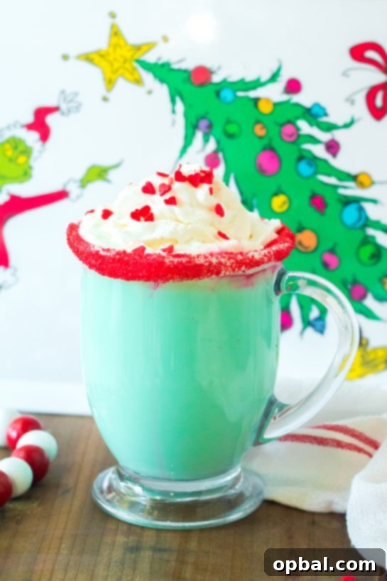 Grinchy Christmas Delight 2 Creamy Grinch Hot Chocolate, a festive green holiday drink topped with whipped cream and red sprinkles.