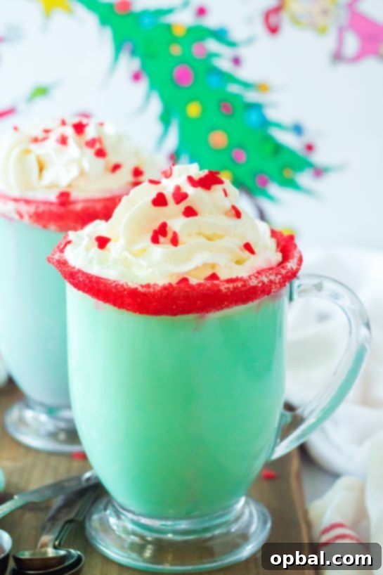 Grinchy Christmas Delight 4 A mug of vibrant green Grinch Hot Chocolate on a festive holiday background with string lights.