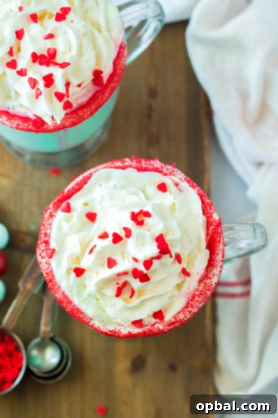 Grinchy Christmas Delight 9 Close-up overhead view of green Grinch Hot Chocolate with whipped cream and red heart sprinkles.