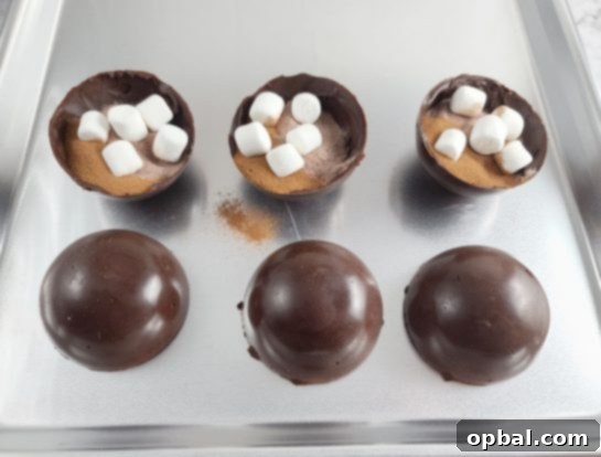Filling chocolate half-spheres with hot cocoa mix, instant coffee, and mini marshmallows.