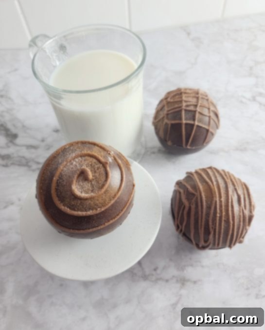 Another close-up shot of the finished Mocha Hot Chocolate Bombs, highlighting their smooth chocolate shells and decorative drizzle.