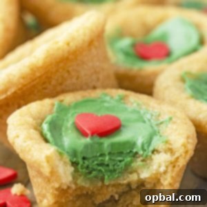 Grinchy Holiday Cookie Cups 12 Grinch Cookie Cup Bites recipe is inspired by Dr. Seuss’s How the Grinch Stole Christmas book/movie! They are chewy sugar cookies that have been colored green and adorned with a red heart for a fun holiday dessert!