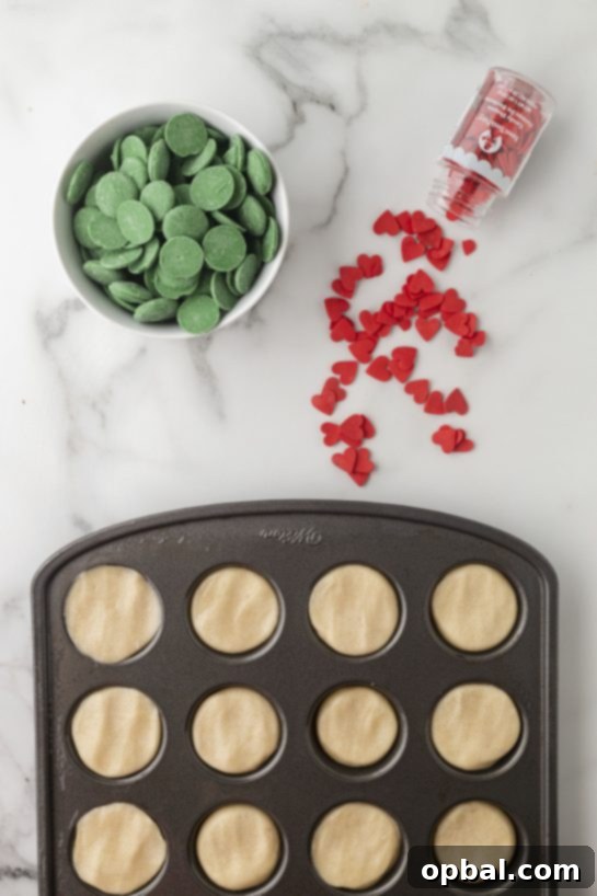 Grinchy Holiday Cookie Cups 4 Pressing down the dough into the muffin tin for the Grinch Cookie Cup Bites recipe