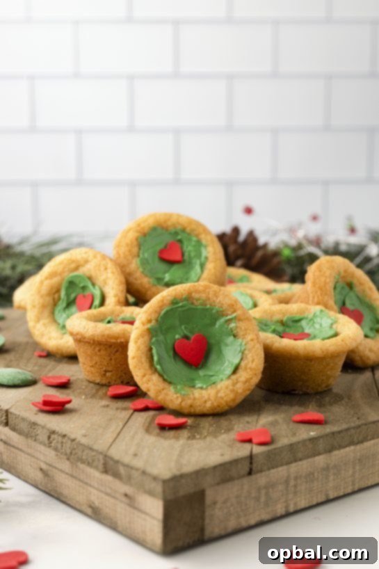 Grinchy Holiday Cookie Cups 9 Green Grinch Cookie Cup Bites recipe is inspired by Dr. Seuss’s How the Grinch Stole Christmas! They are chewy sugar cookies that have been colored green and adorned with a red heart for a fun holiday dessert!