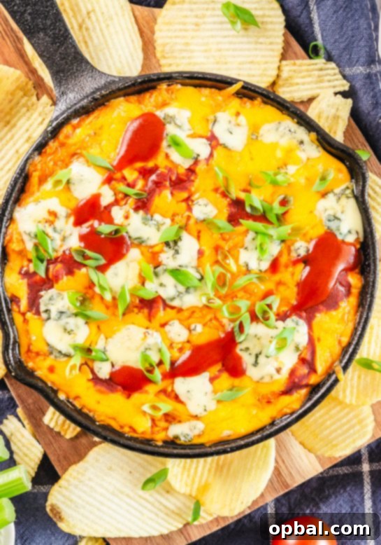 Ultimate Game Day Buffalo Chicken Dip 4 Warm Buffalo Chicken Wing Dip served in a cast iron skillet, garnished with fresh green onions.