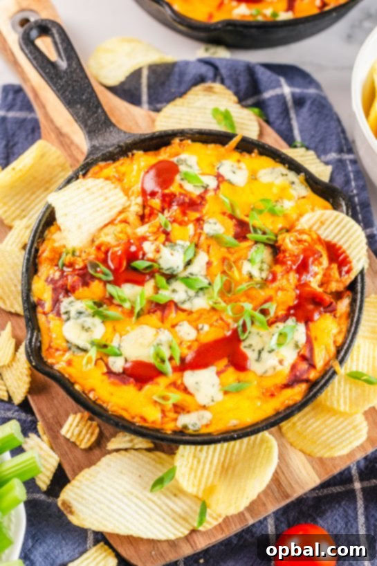 Ultimate Game Day Buffalo Chicken Dip 5 Overhead view of a baking dish filled with hot Buffalo Chicken Wing Dip, surrounded by dippers.