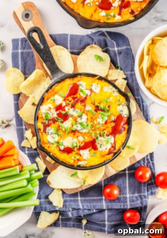 Ultimate Game Day Buffalo Chicken Dip 9 Overhead shot of the finished Buffalo Chicken Wing Dip in a cast iron skillet, garnished with green onions.