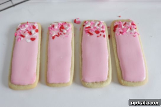 Smooth Royal Icing for Beautiful Sugar Cookies 5 Photo of applying the easy sugar cookie royal icing recipe to the sugar cookies for any holiday or party