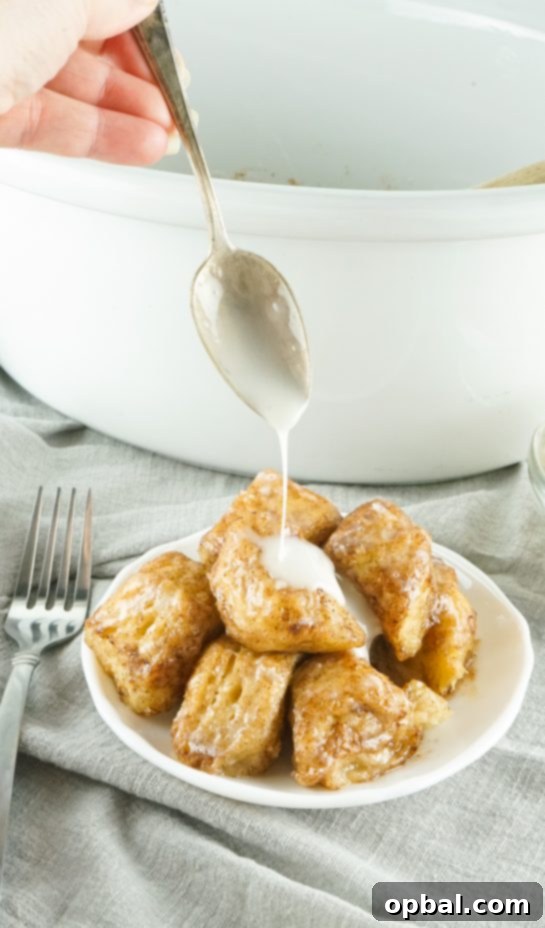 Crockpot Pull-Apart Perfection 10 Slow Cooker Monkey Bread turns your classic monkey bread recipe into a delicious slow cooker creation. Full of delicious biscuits, coated in cinnamon and sugar, then drizzled with a rich icing. Perfect for brunch, breakfast or dessert.