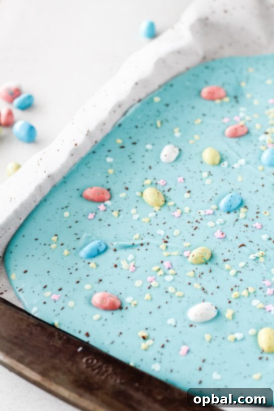 Speckled Robin's Egg Easter Bark 6 Sprinkling vibrant Easter sprinkles and placing individual Robin Eggs onto the still-soft blue chocolate bark.