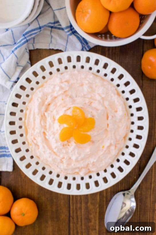 A bowl of fluffy Orange Creamsicle Salad, featuring creamy whipped layers with mandarin oranges, ready to be served.