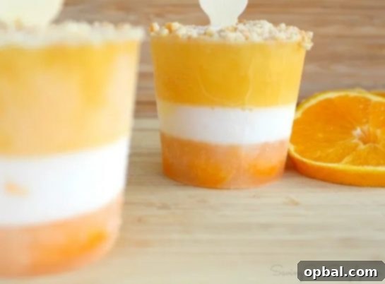 Several Homemade Orange Creamsicle Popsicles, showing the distinct layers of orange and creamy white, ready for a refreshing bite.