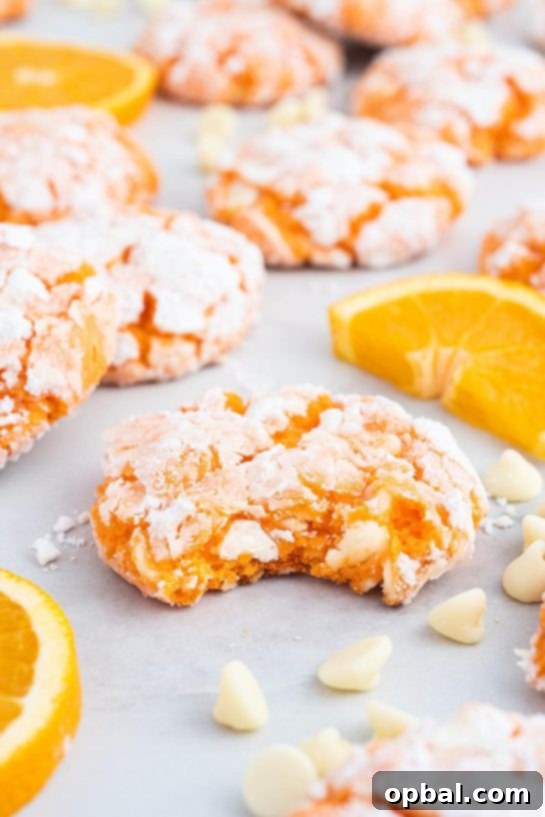 A pile of freshly baked Shortcut Creamsicle Cookies with a slightly chewy texture and a dusting of powdered sugar.