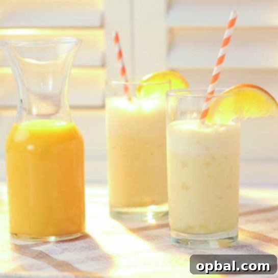 A vibrant Orange Cream Smoothie in a glass with a straw, garnished with an orange slice, perfect for a quick and healthy treat.