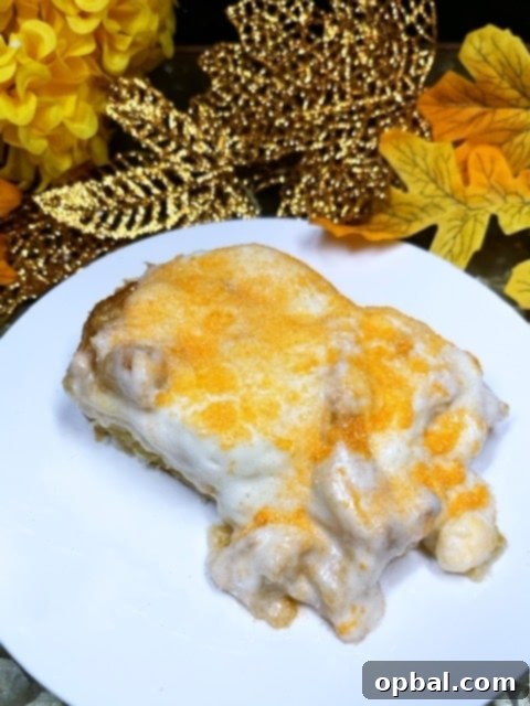 Warm Orange Creamsicle Cinnamon Rolls drizzled with a creamy orange glaze and topped with orange sprinkles, served on a baking sheet.
