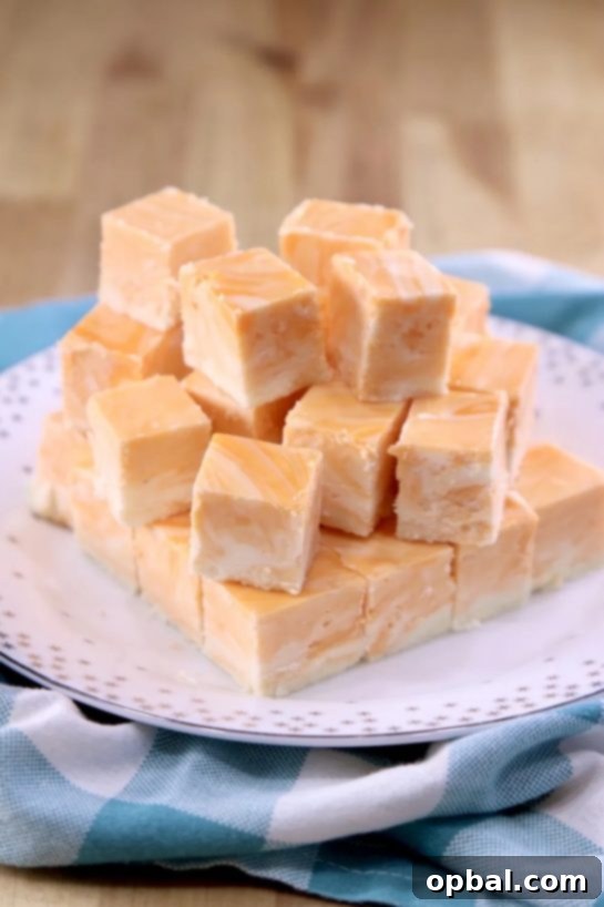 Close-up of Orange Creamsicle Fudge squares, showing creamy layers of orange and white, ready to be enjoyed.