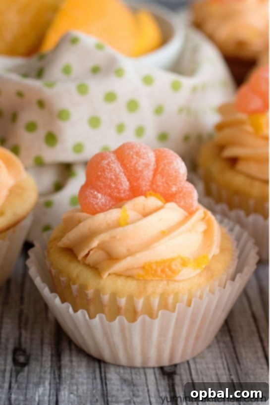 Delicious Orange Creamsicle Cupcakes topped with a swirl of orange buttercream icing, garnished with candied orange peel.