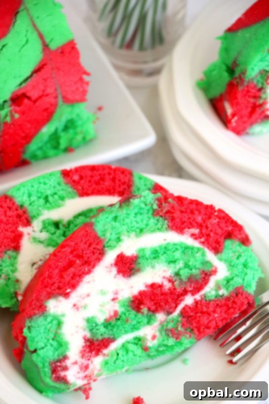 Festive Yule Log Cake 2 Christmas Cake Roll is a festive and easy holiday dessert, perfect for family and friends. This vanilla sponge cake with whipped frosting embodies the joyful spirit of Christmas with vibrant colors.