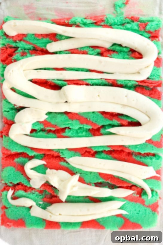 Festive Yule Log Cake 6 Applying a generous layer of light vanilla whipped frosting onto the perfectly baked and cooled cake, ready for rolling.