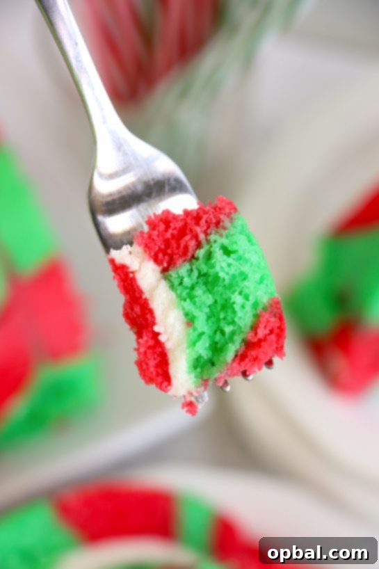 Festive Yule Log Cake 9 A perfectly sliced Christmas Cake Roll showcasing its festive red and green swirl, a beautiful holiday dessert to share with family and friends.