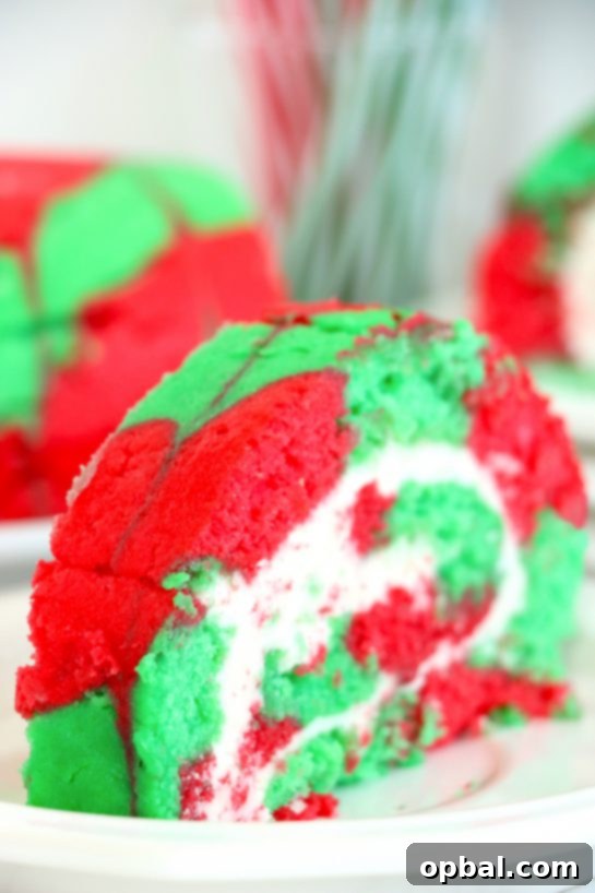 Festive Yule Log Cake 10 Enjoy a delightful slice of Christmas Cake Roll, featuring vibrant holiday colors and a smooth, creamy filling – an easy yet elegant dessert for your festive gathering.