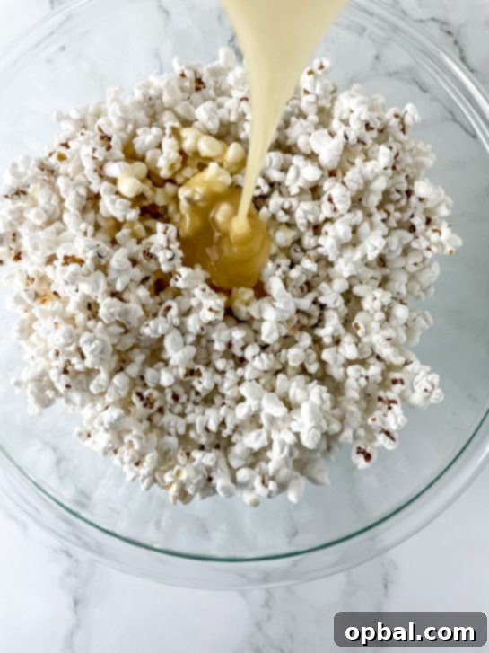 Sparkling New Year Popcorn Bites 4 Mixing the fluffy popcorn with the warm, golden Champagne marshmallow syrup to create the New Year Popcorn Balls.
