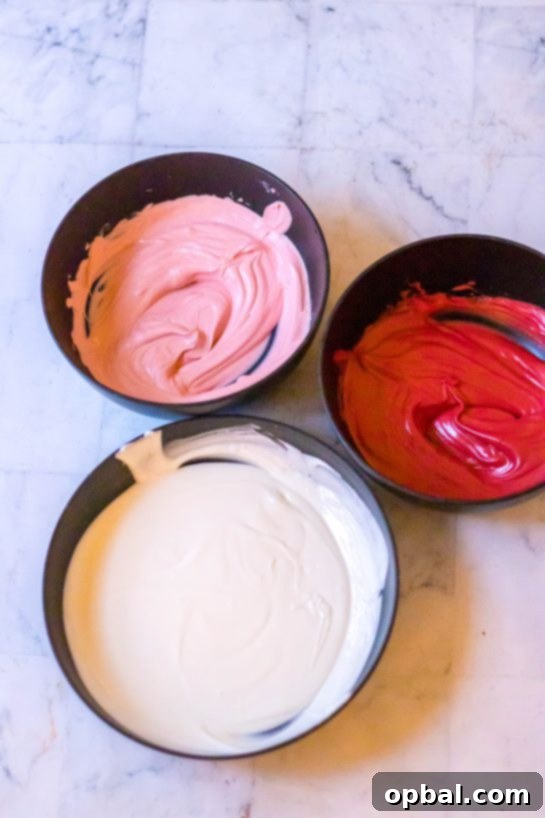 Sweet Valentine's Millionaire Bars 5 Decadent white, red, and pink melting chocolates in separate bowls, ready to be swirled together to create the festive topping for the Valentine's Day Millionaire Bars.